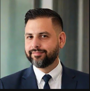 Adam Howell in a suit — bases himself in Asia to stay out of reach of USA law enforcement